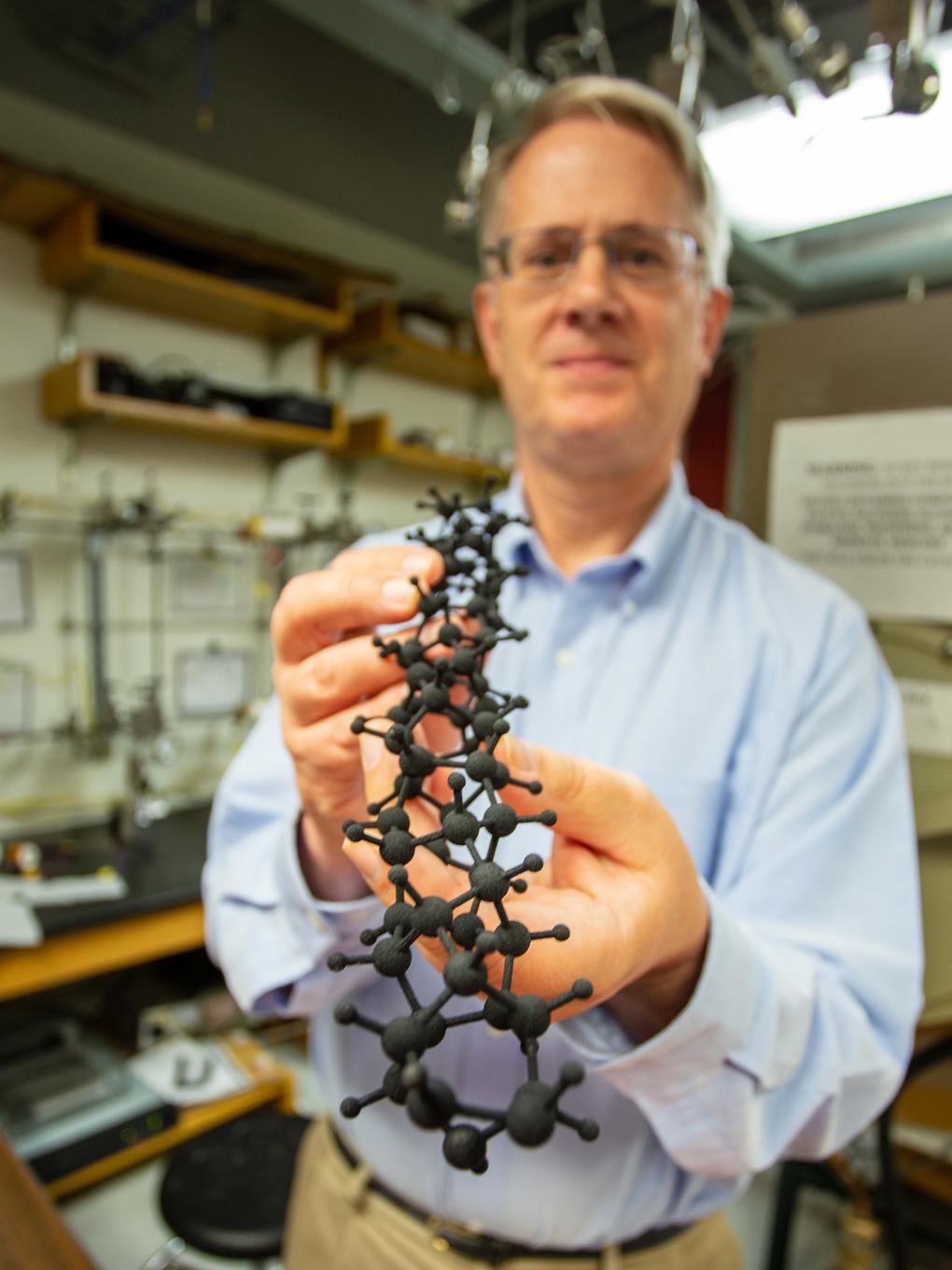 John Badding holding 3D model of nanothread