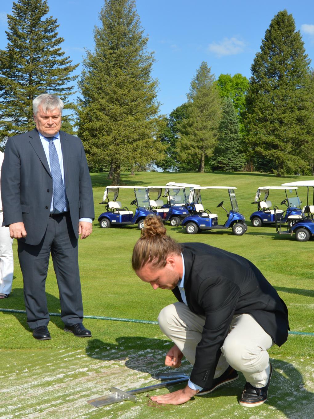 Hunter Swisher demonstrates for President Eric Barron how Rhizosorb causes plant roots to grow longer