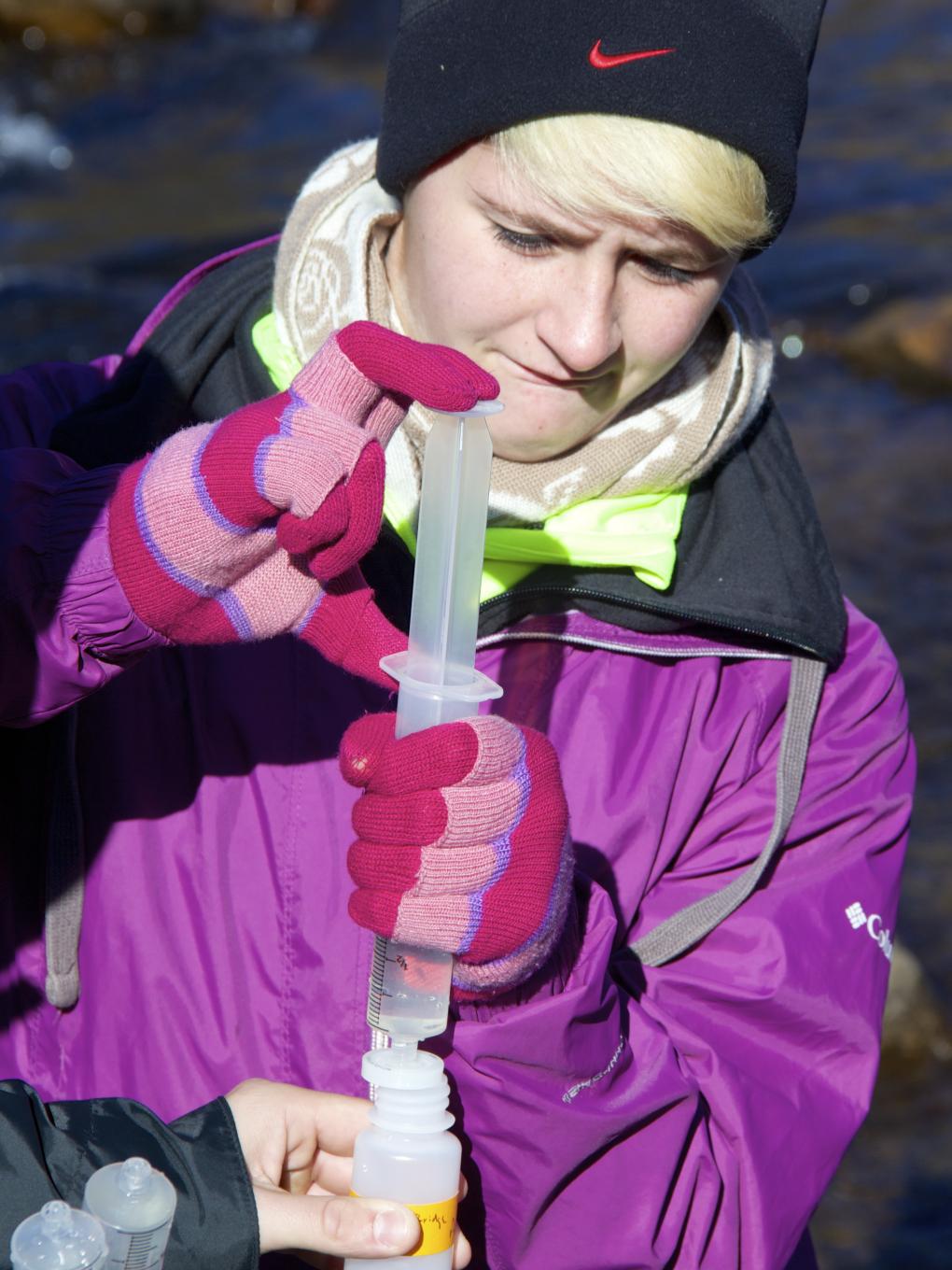 A State College high school student collects a water sample during a TeenShale Network field trip with Penn State researchers 
