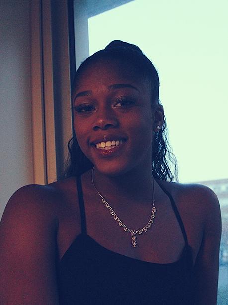 Kay Adetiba stands in front of a window