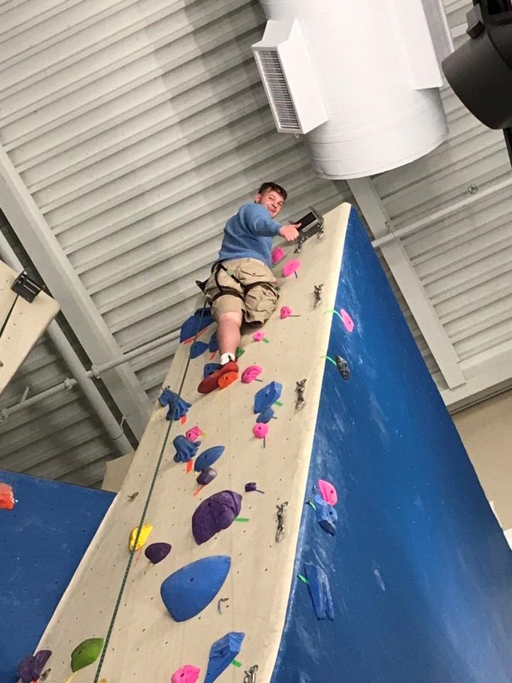 RJ Shirey climbs a rock wall