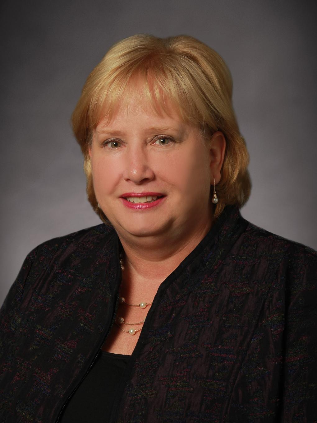 Blonde woman smiling in a posed headshot photo