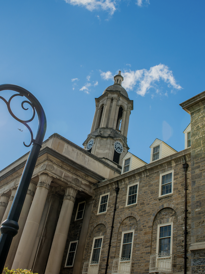 detail photo of Penn State Old Main building with sunny sky