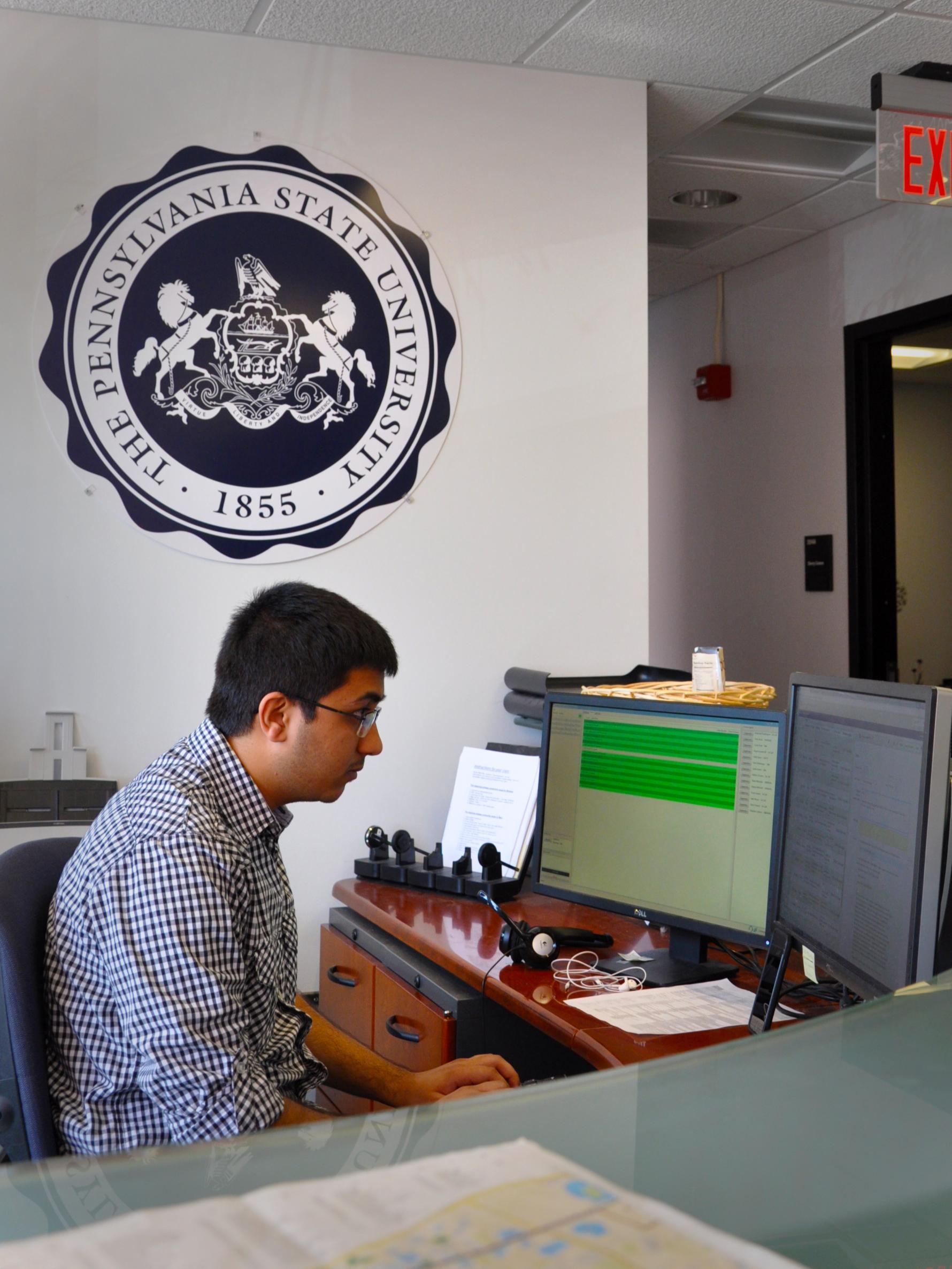 Karan Kalaria monitors incoming help requests at a desk at the IT Service Desk. 