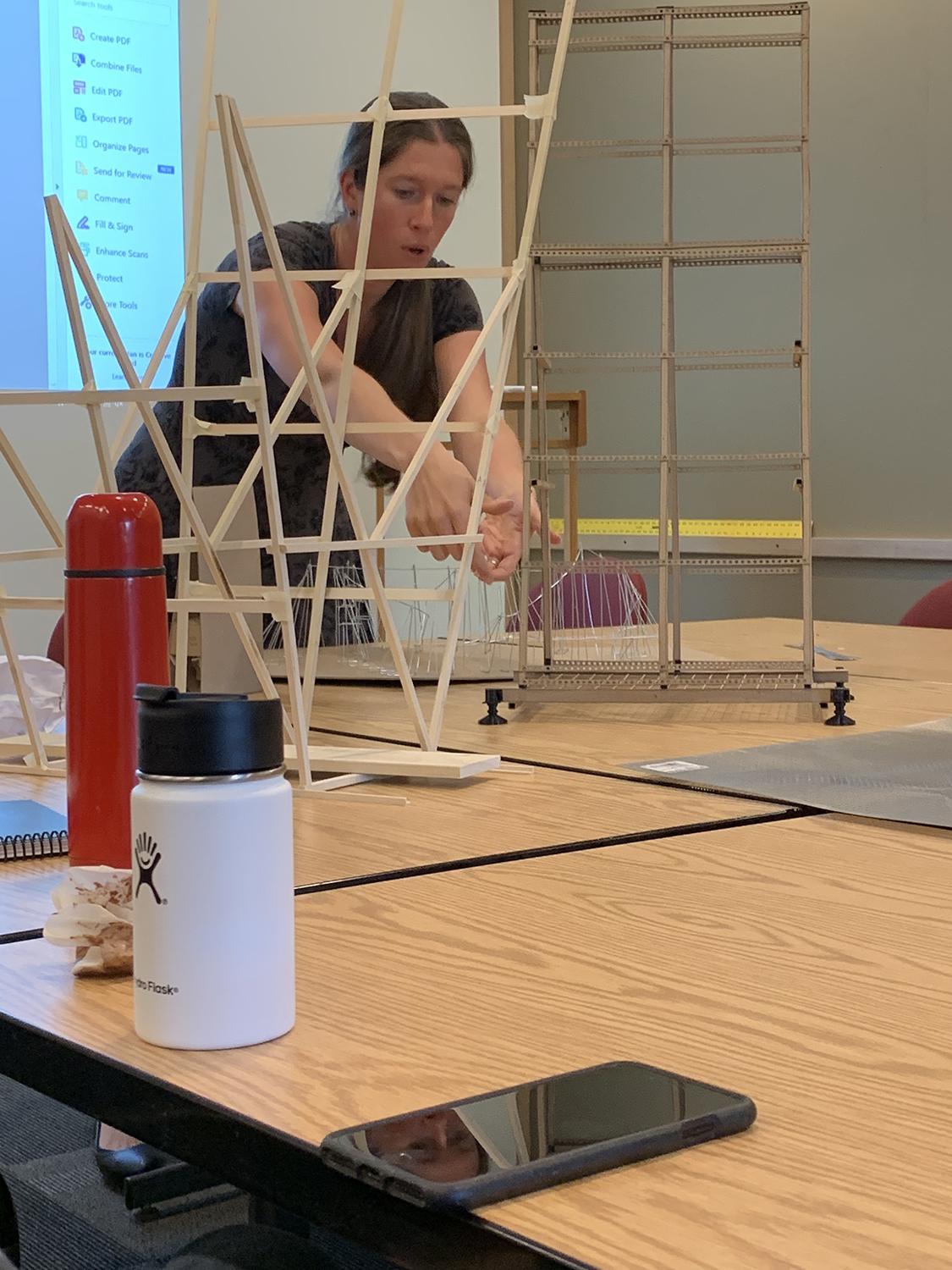Gillean Denny leans over a wooden model on a table.