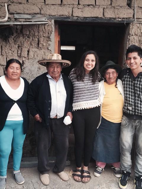 student stands with host family
