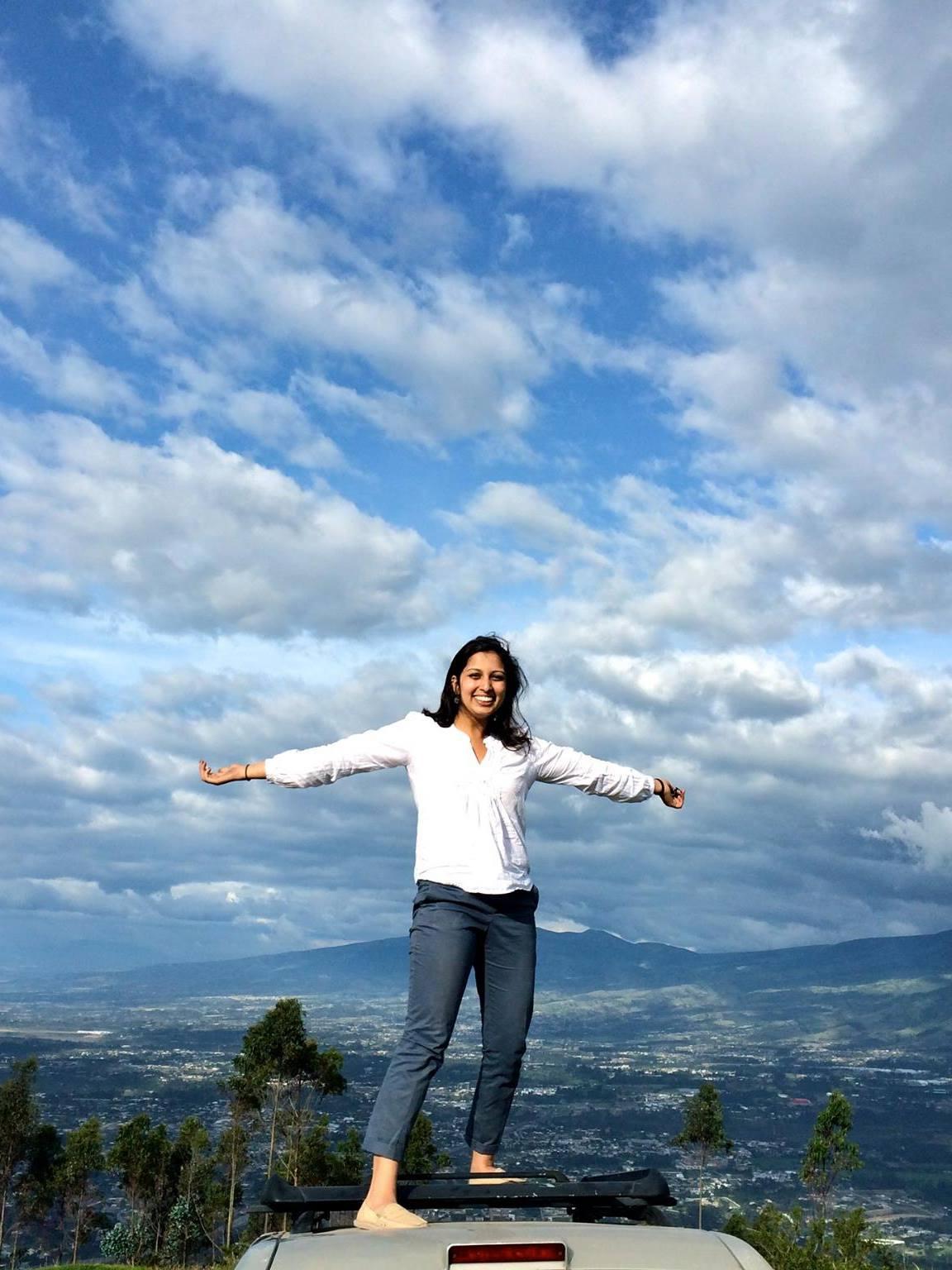 student poses in front of Ecuadorian landscape