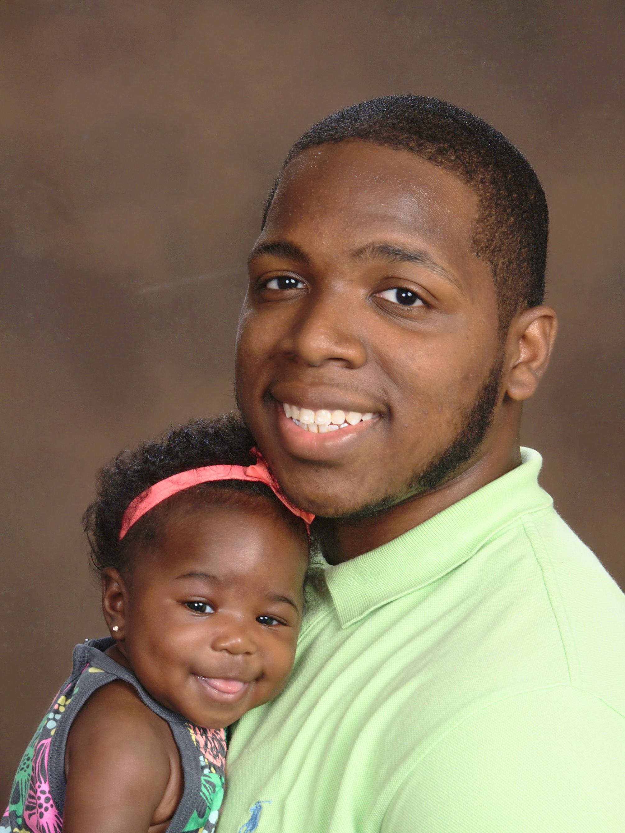 Headshot of Gregory Hines-Garrison and baby daughter