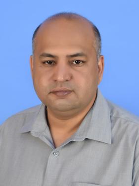 A professor poses for a professional headshot.