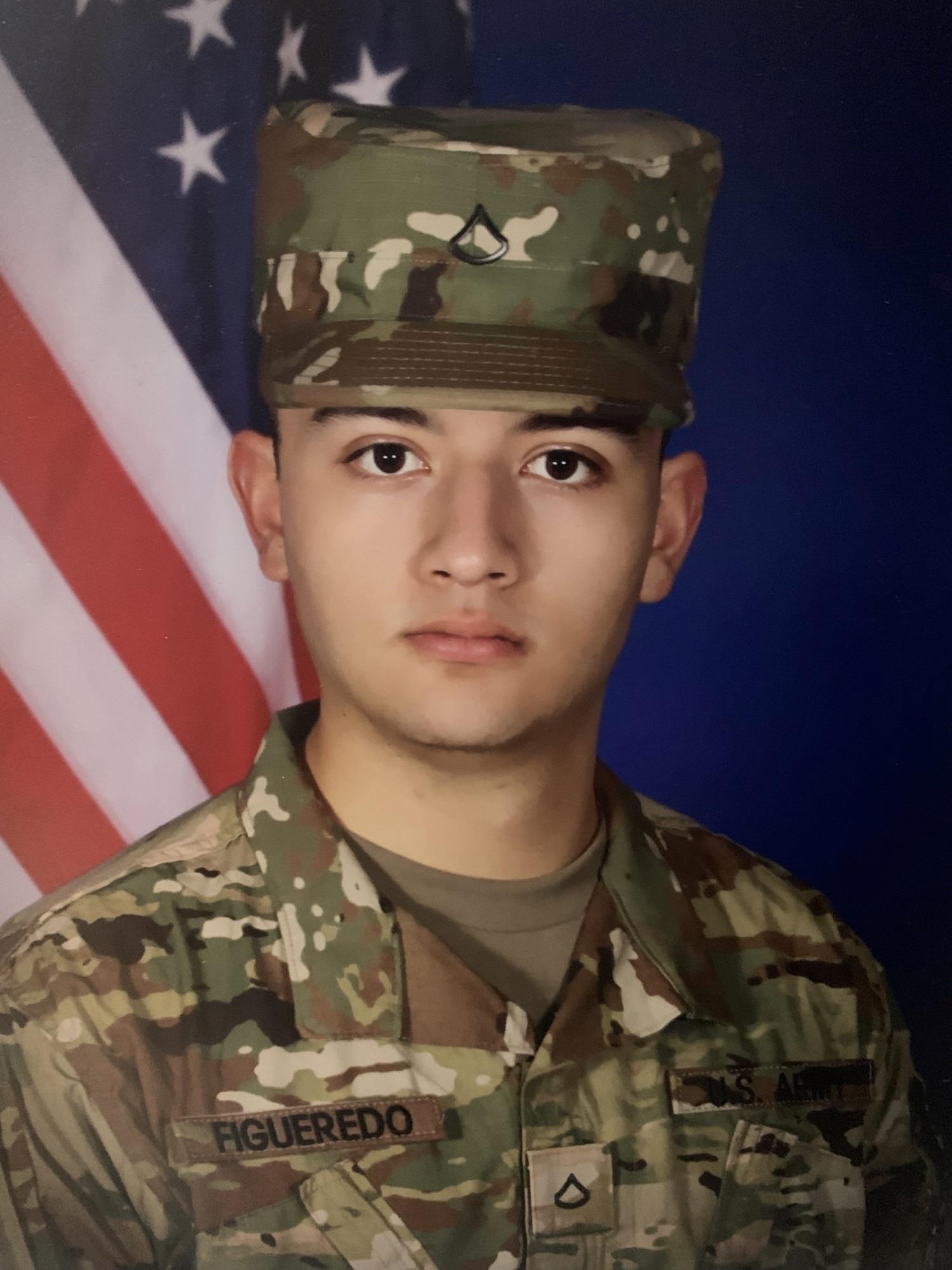 Military service man looks at camera in uniform