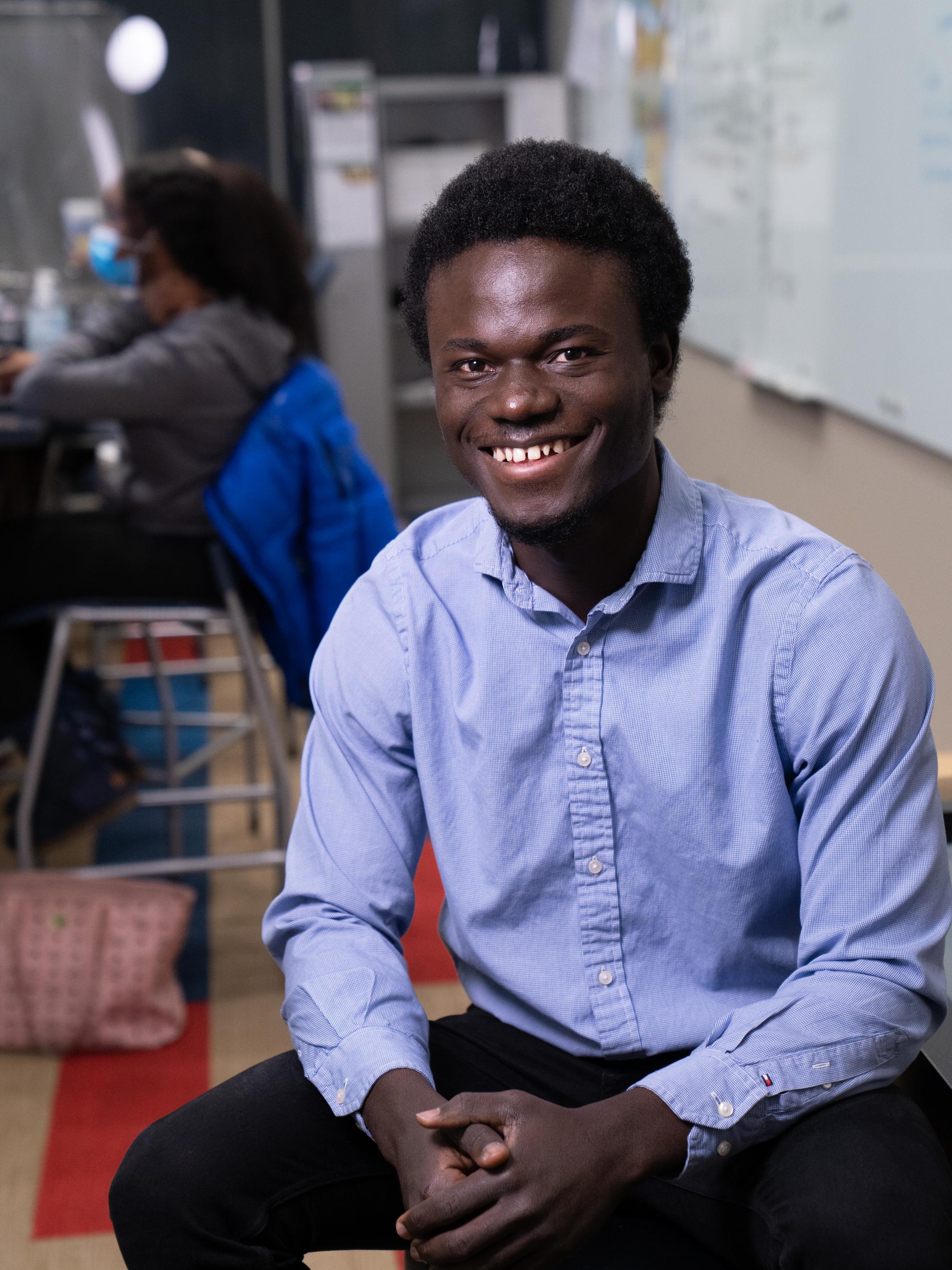 Edward Amoah sitting on a stool while being interviewed