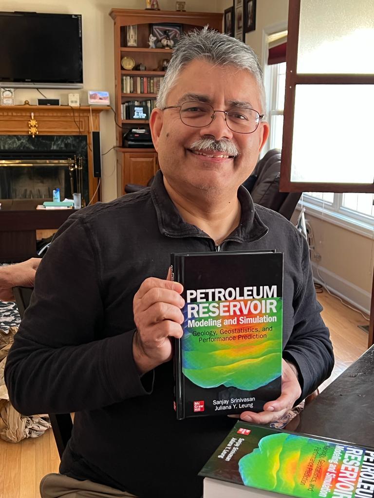 Sanjay Srinivasan smiling while holding his book