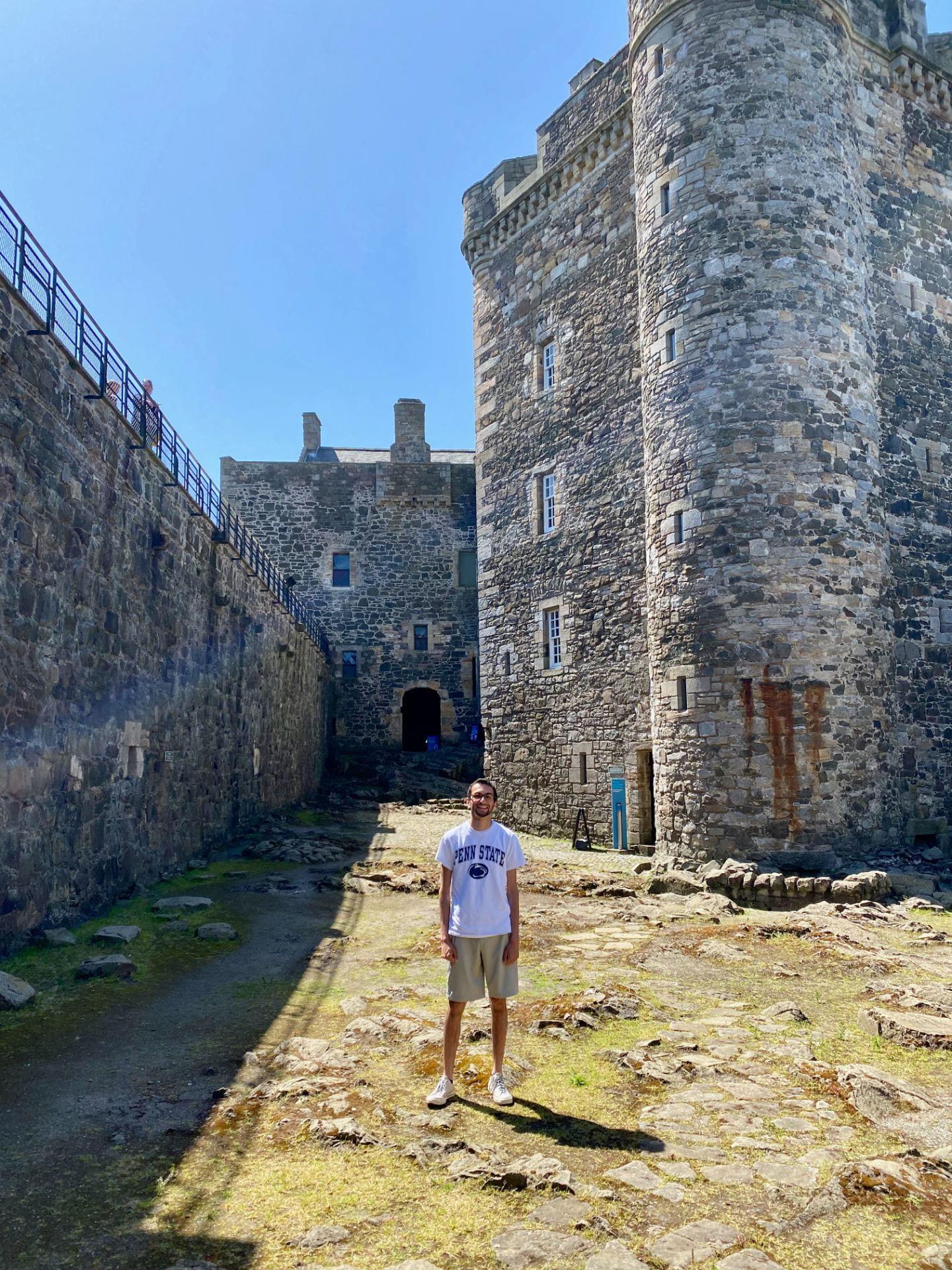 Man stands in front of a castle 