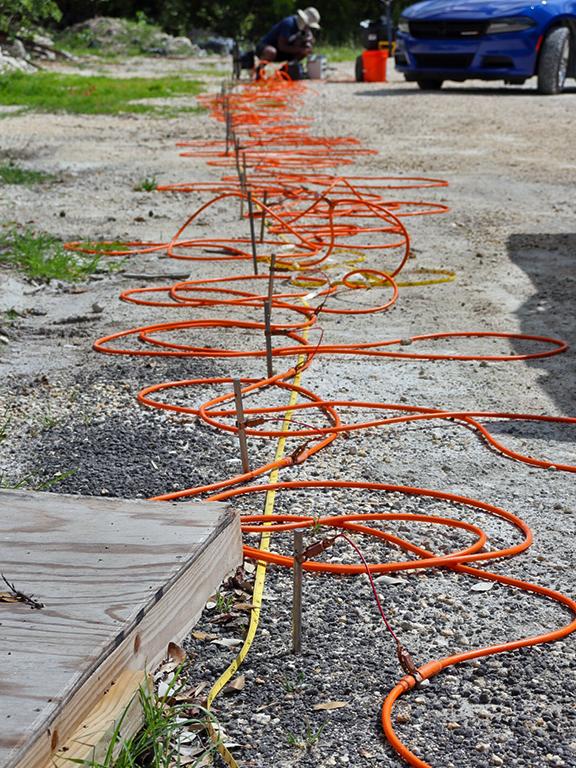 Cameron Brown connects a series of probes that have been installed just inches into the ground. 