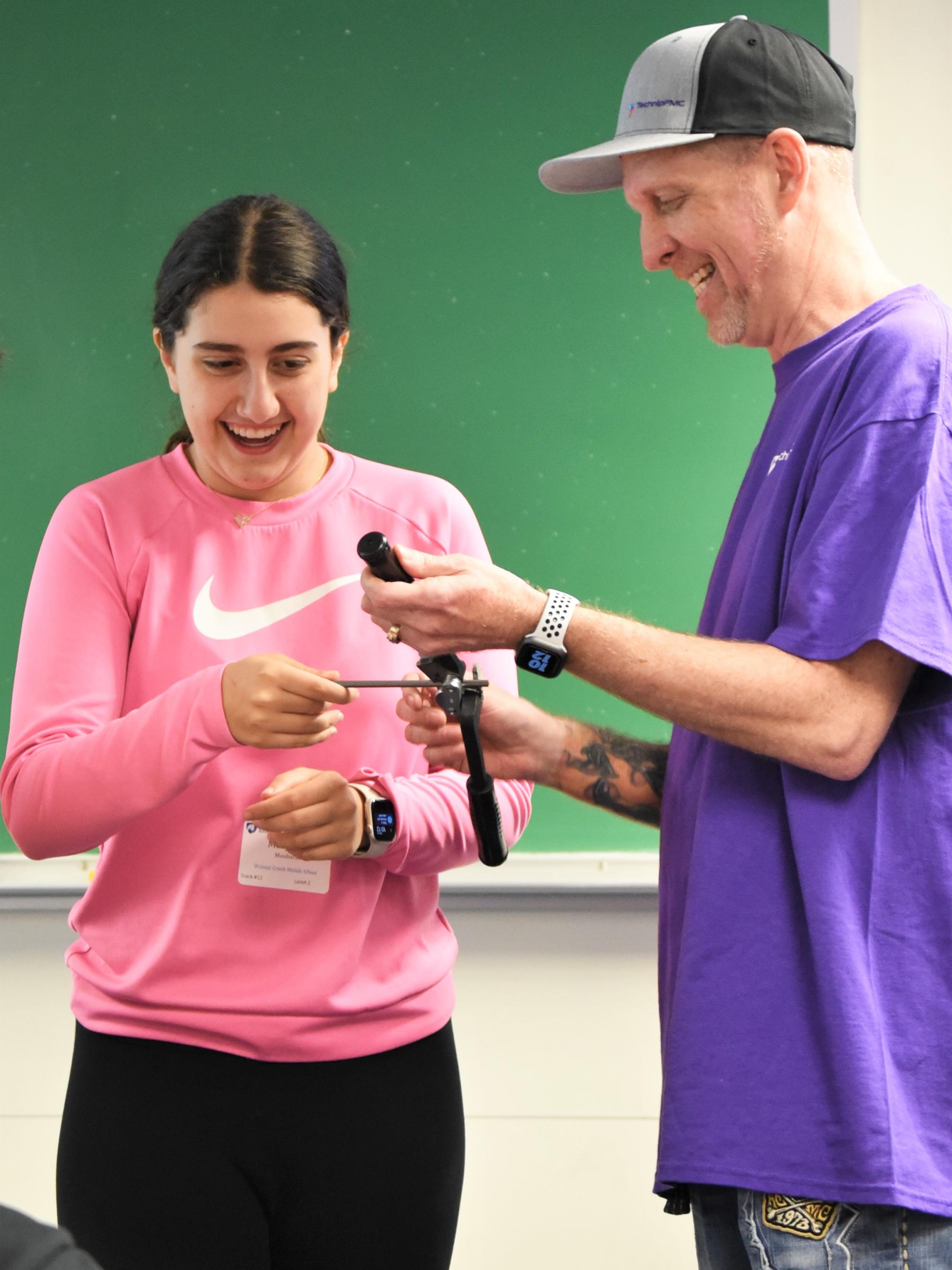 A middle-school student learns how to bend and cut a steel pipe during Penn State Behrend's Math Options Career Day.