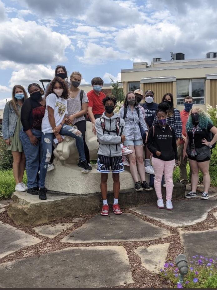 Students standing in front of a statue of the Nittany Lion.