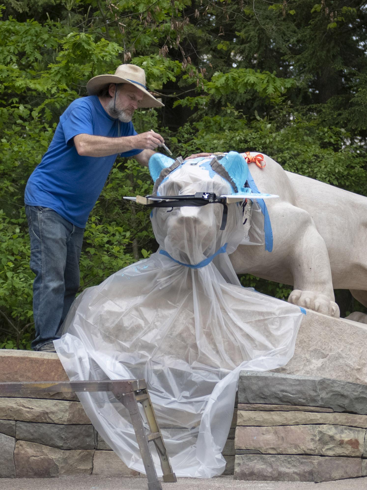 Curtis Martin, a stone sculptor and conservator with McKay Lodge Conservation Laboratory, carefully applies casting to both ears on the Nittany Lion Shrine.