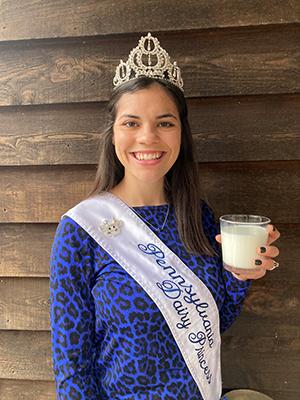 Mikayla Davis wears a crown and Pennsylvania Dairy Princess sash while holding a glass of milk.