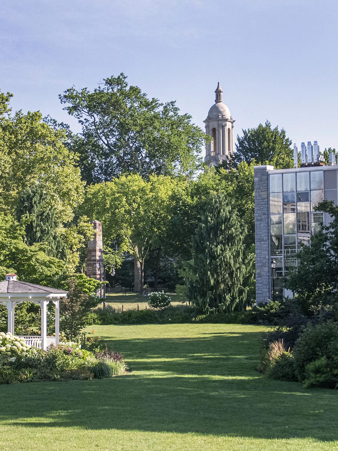 Hintz Family Alumni Center lawn on a sunny day with the Old Main bell tower in the background