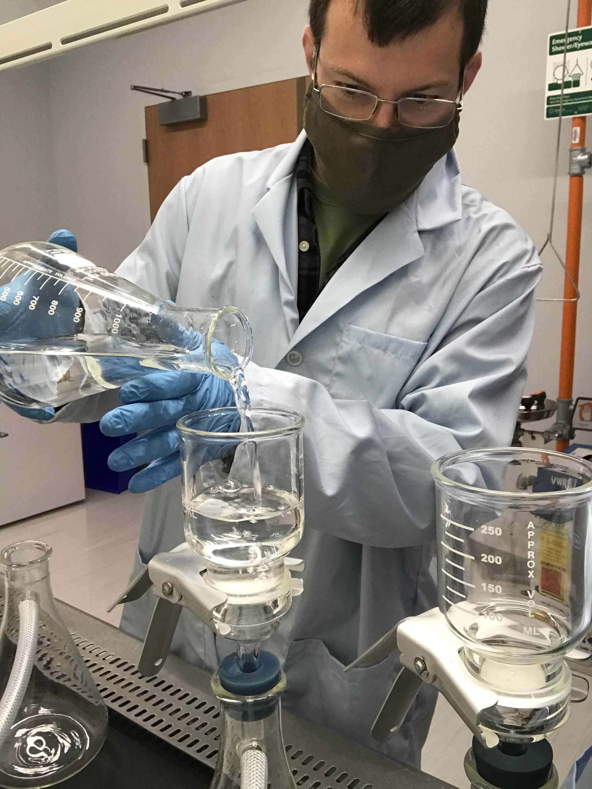 Man pouring water sample into beaker