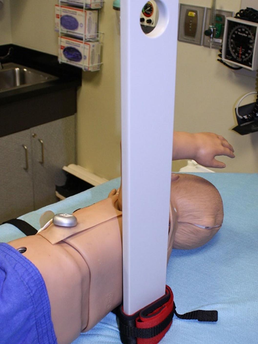 A pediatric mannikin is pictured with a custom-designed backboard used for CPR.