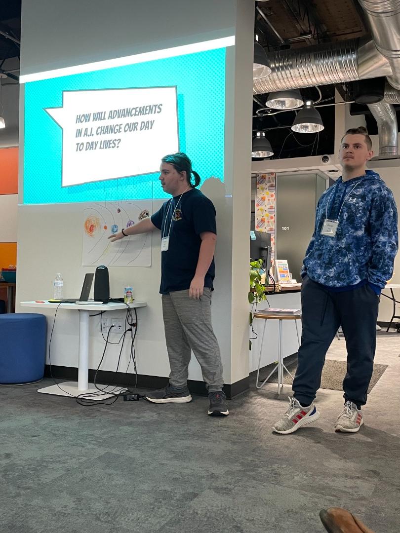 Students giving a presentation in front of a screen.