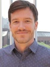 Roger Beaty headshot with short brown hair and blue button down shirt.