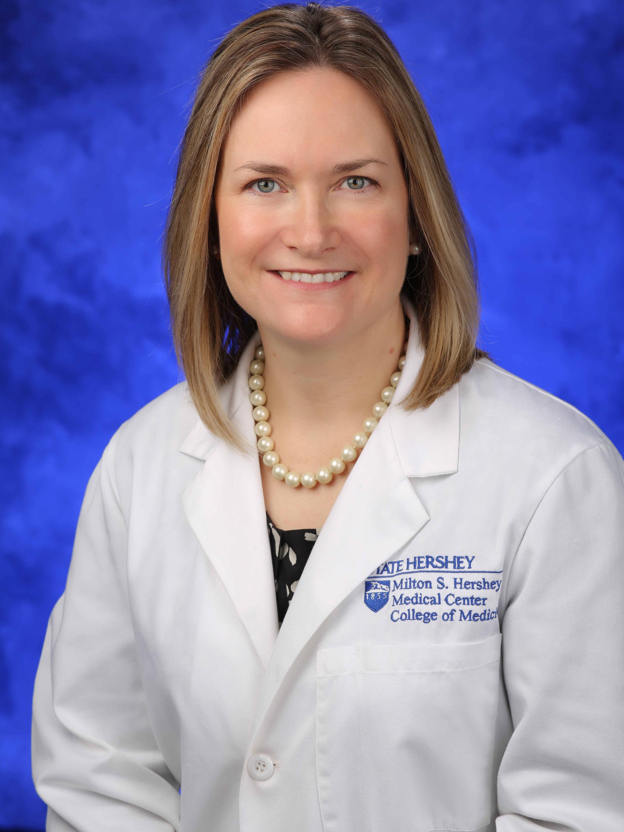 Dr. April Armstrong poses for a photo wearing her white physician coat.