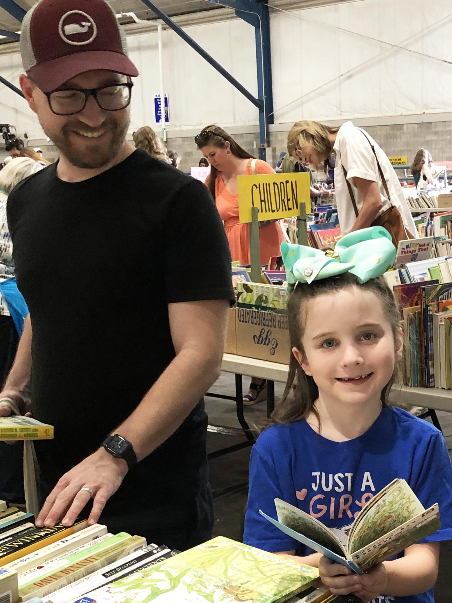 A father and daughter peruse books at the AAUW State College used books sale.
