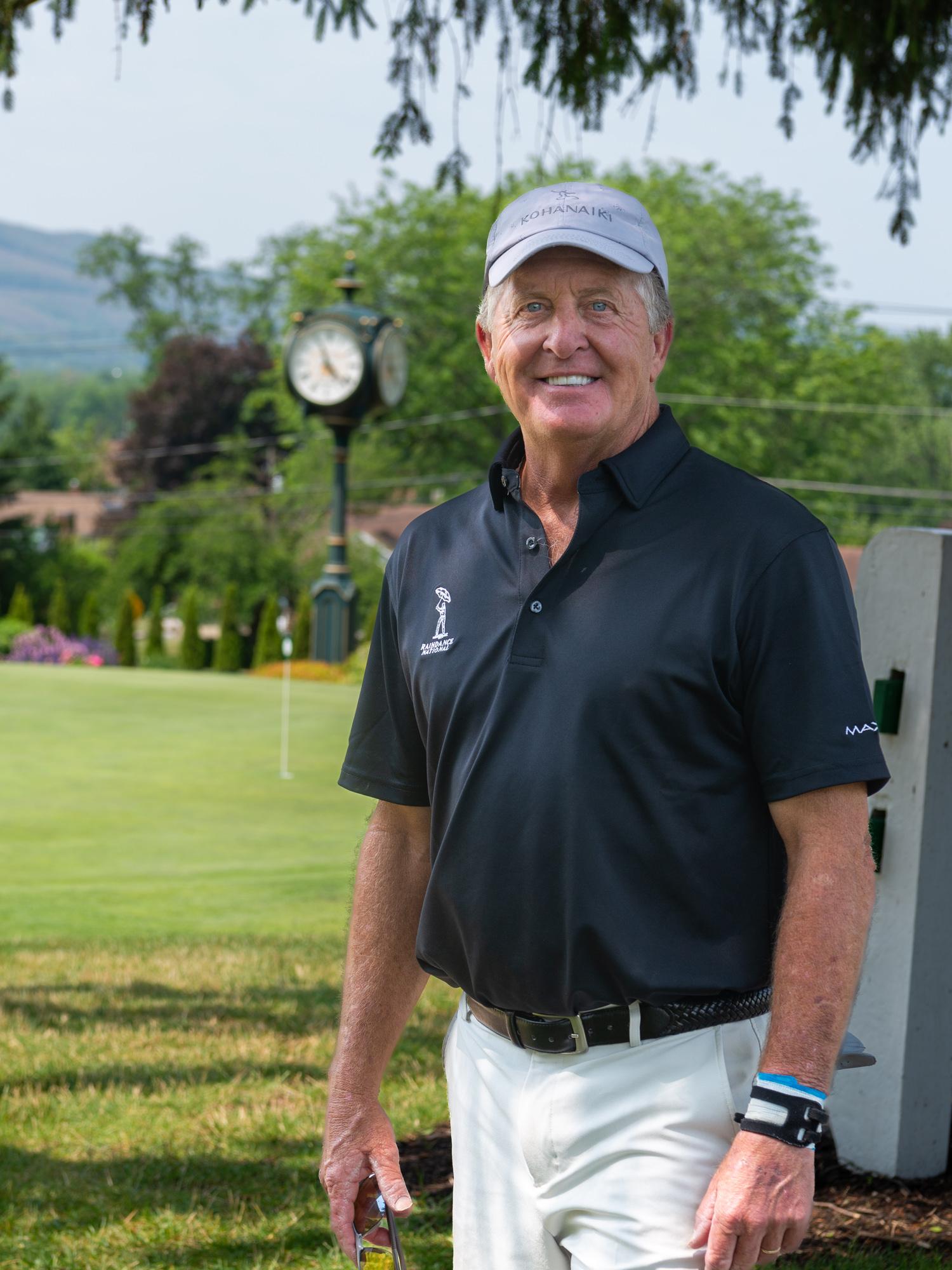 Fred Funk standing outside on a beautiful day, wearing a blue polo and white pants. He is smiling.