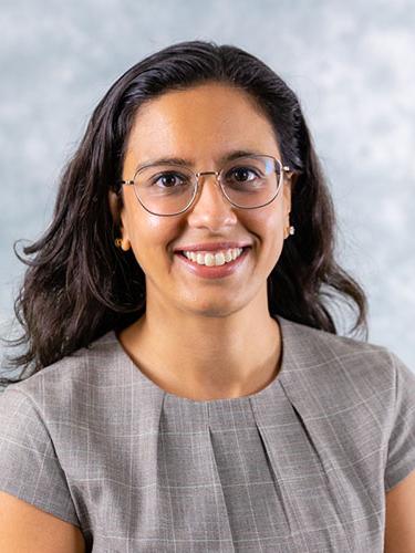 head shot of dark-haired woman wearing glasses