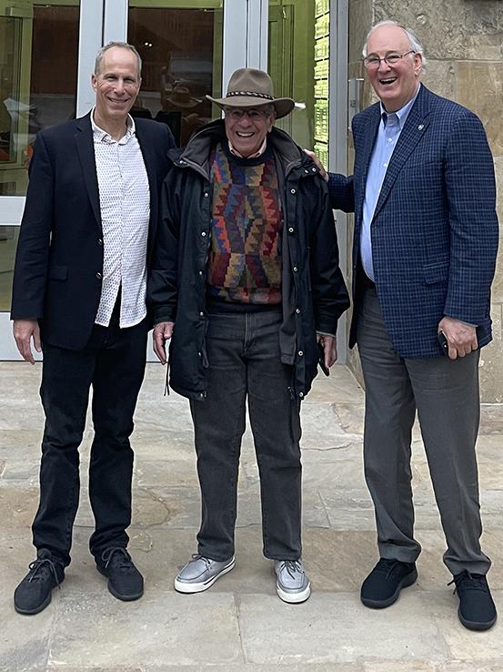 Boaz Dvir standing with two men and smiling at the camera
