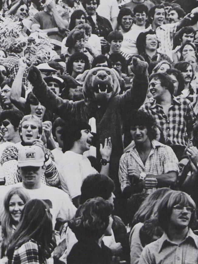 A black and white photo of football fans in the stands in 1976, with the Nittany Lion