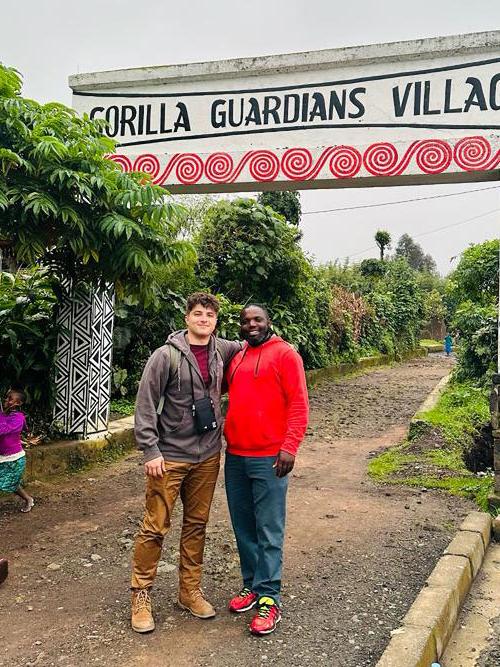 Brandon George and a local outside the entrance to the Gorilla Guardians Village