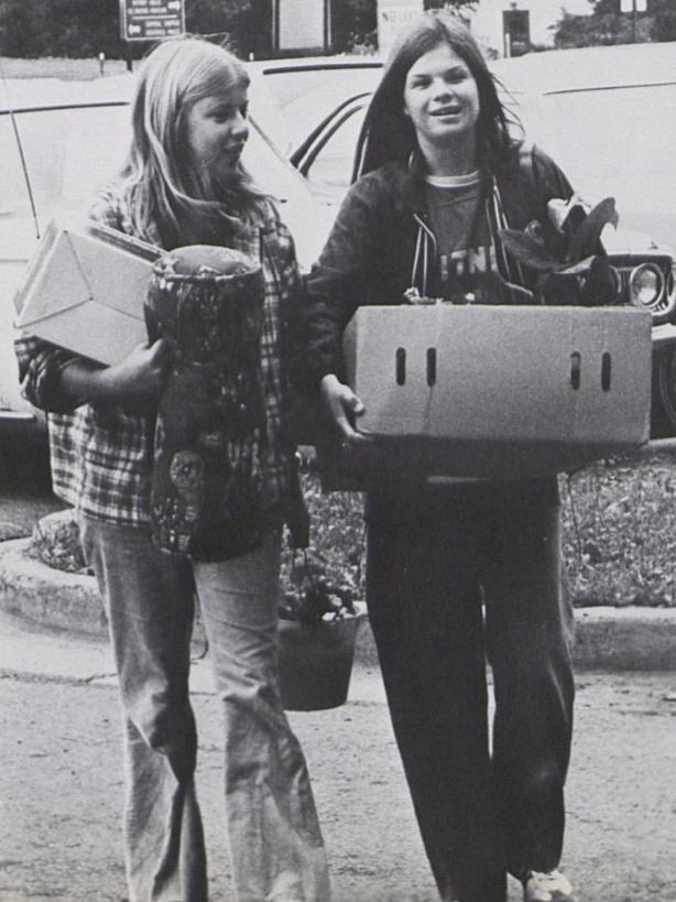 Two female students carry their belongings on move-in day