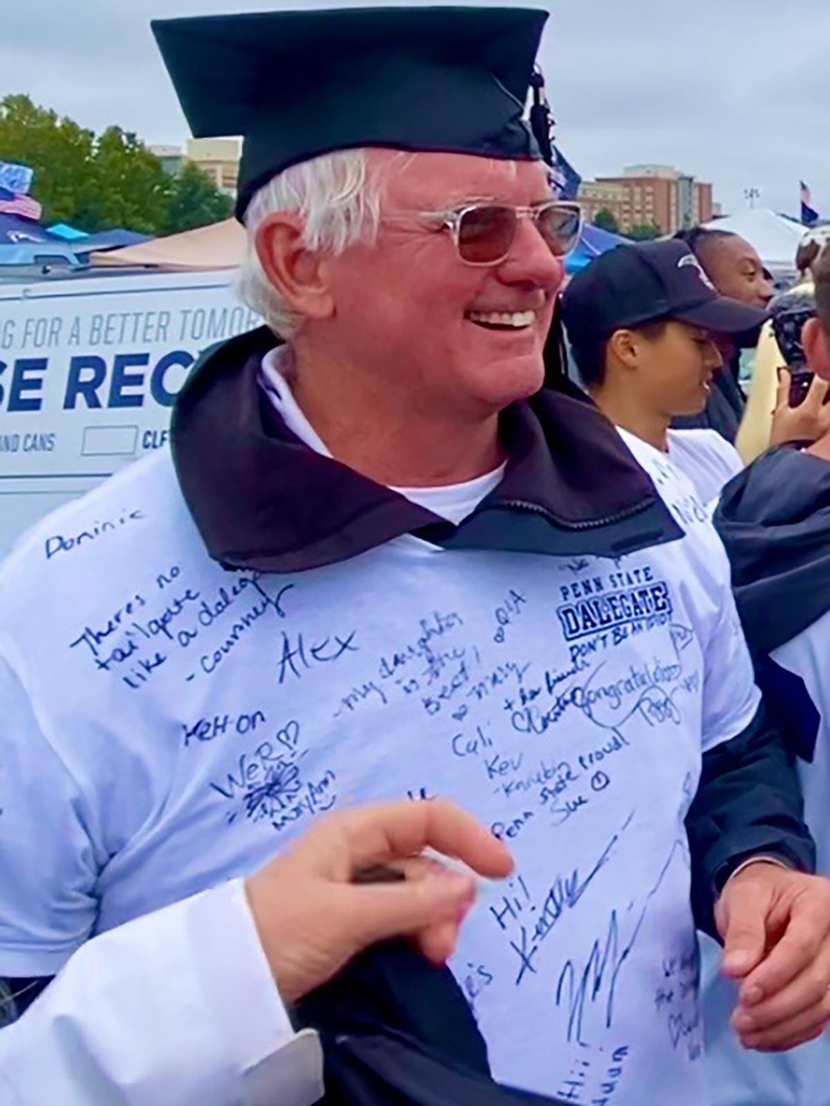 A photo of Dale Quayle wearing a graduation cap and a T-shirt signed by well wishers.