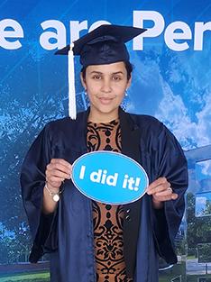 A woman poses in front of a Penn State themed background.