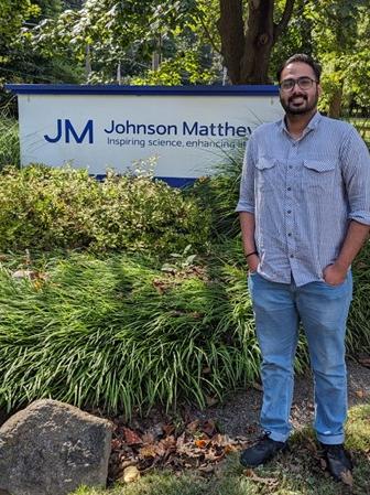 Parth Trivedi standing next to the Johnson Matthey sign