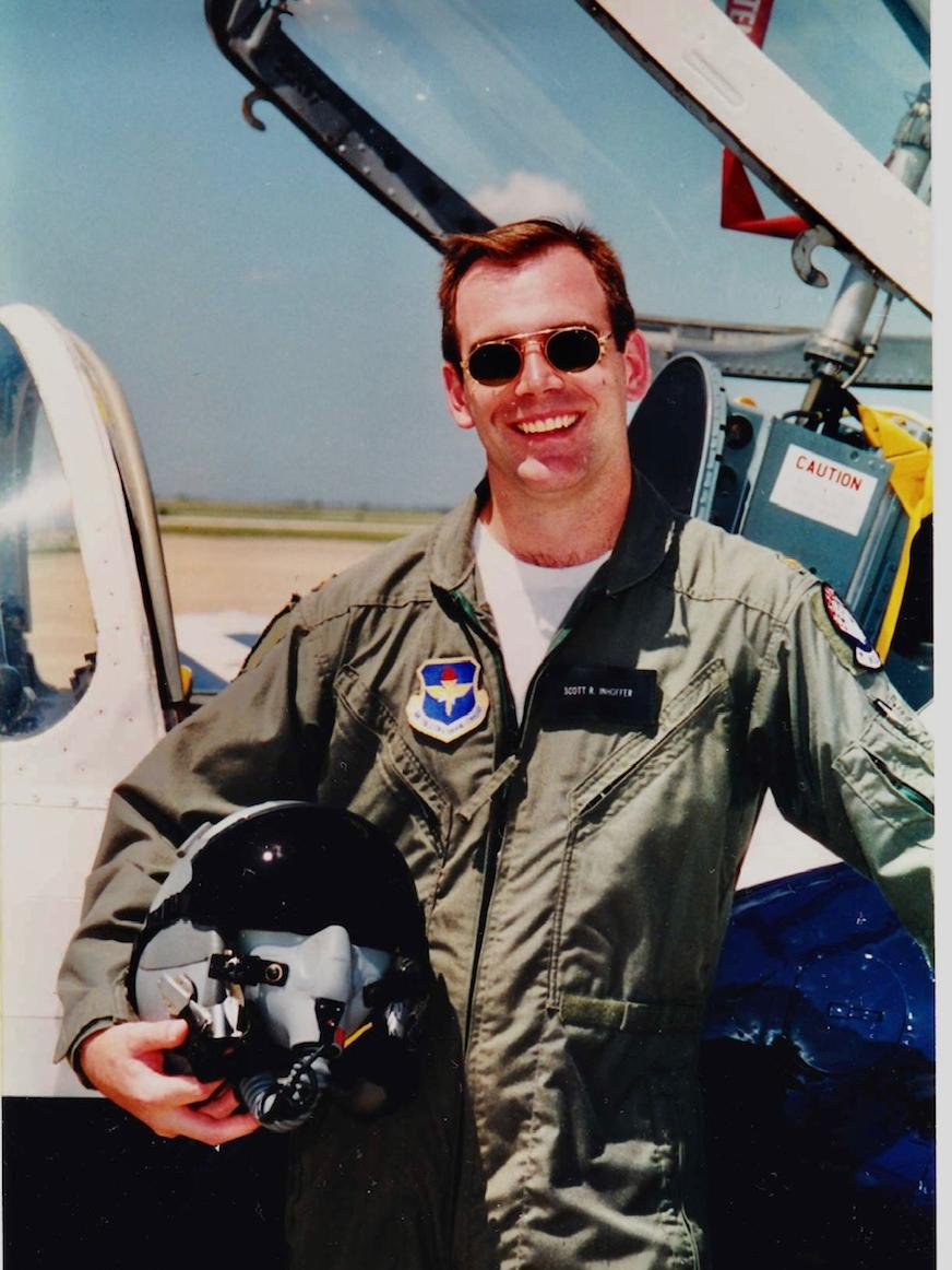 Scott Inhoffer in front of a jet airplane that has the cockpit door open