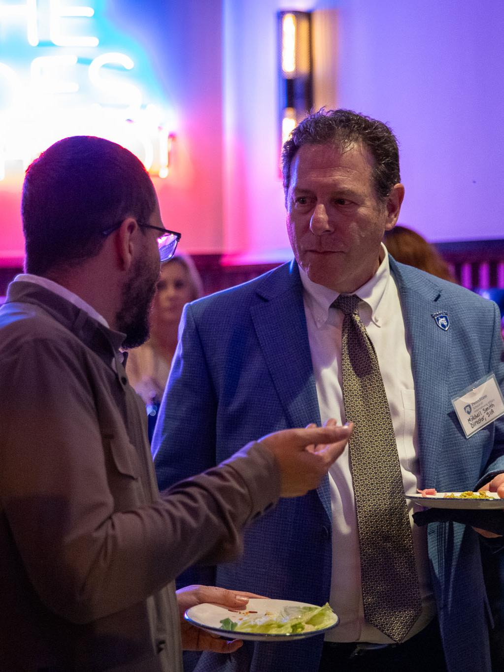 SIA Director Mitchell Smith engages with an alumnus at the reception.