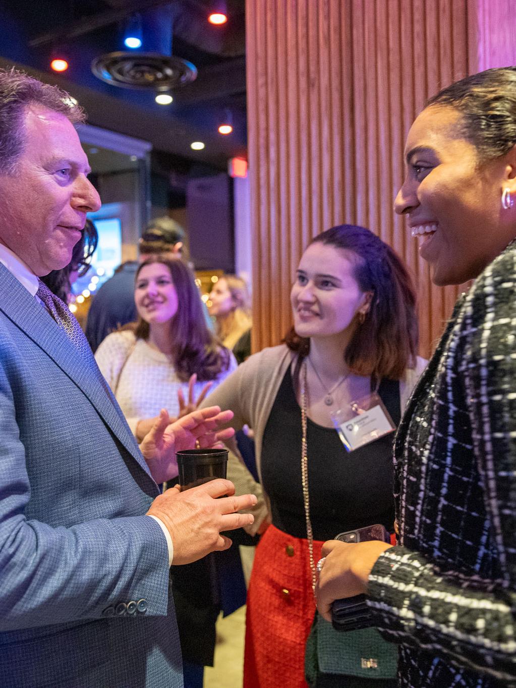 SIA Director Mitchell Smith speaking with 2022 alumna Adriana Rivera.