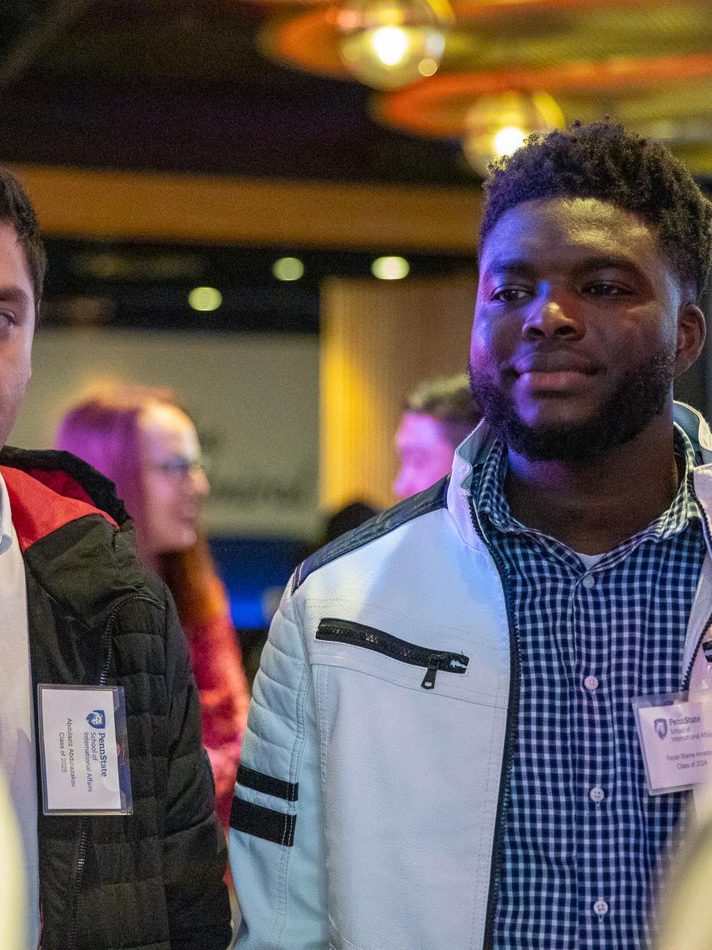 Second-year master's student Rayan Mama Amadou interacts with a group of students and alumni at the reception.