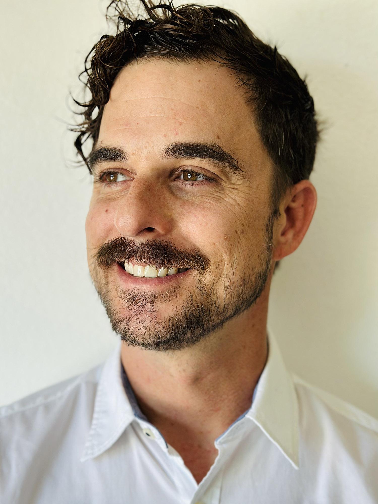 a headshot of a man smiling