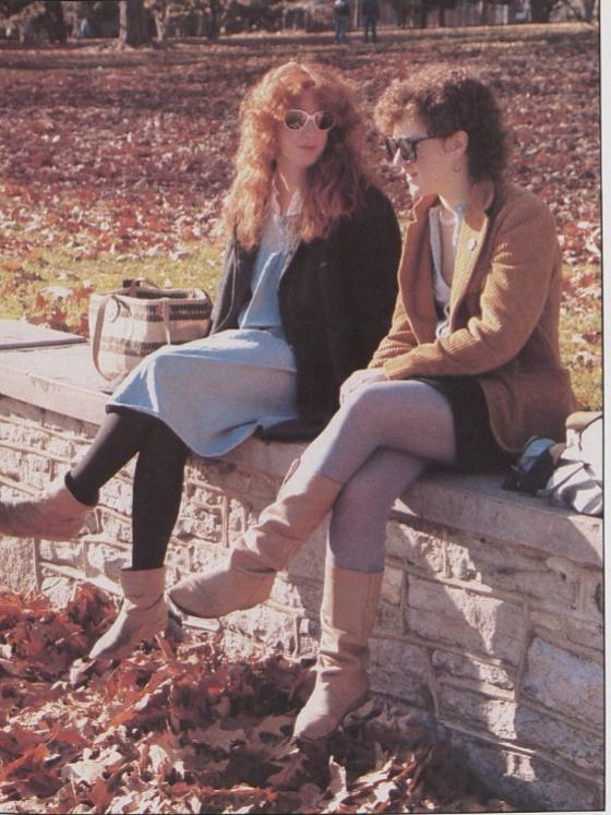 Two students sit on a stone wall