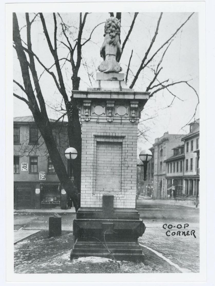 The rear of a stone pillar with a lion statue on top of it