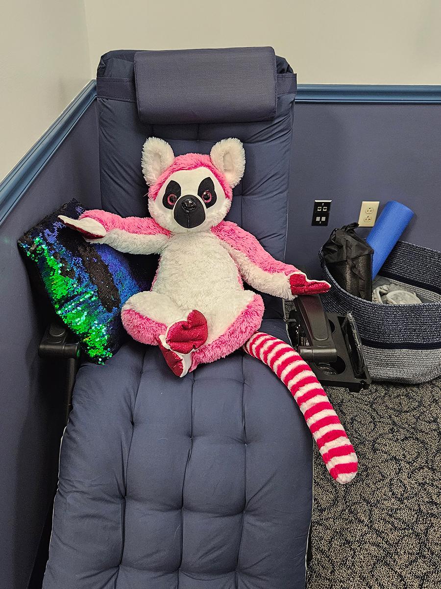 a blue gravity chair with a pink stuffed animal sitting on it