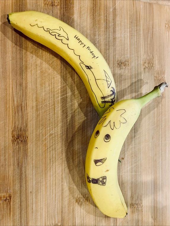 A picture of a banana with drawings on the skin.