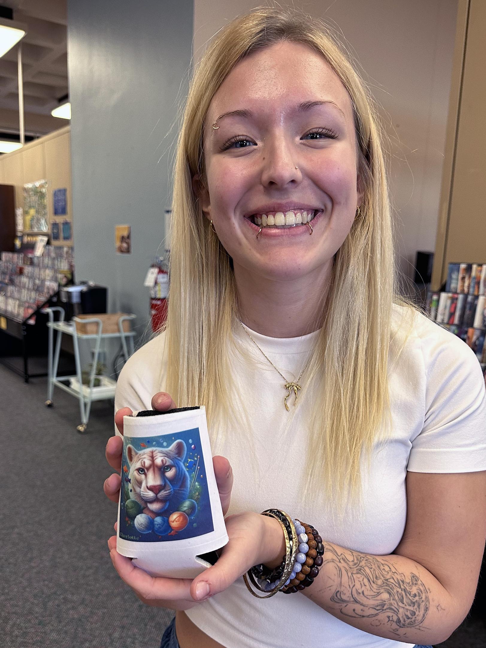 A student holds a coffee mug with a lion design on it