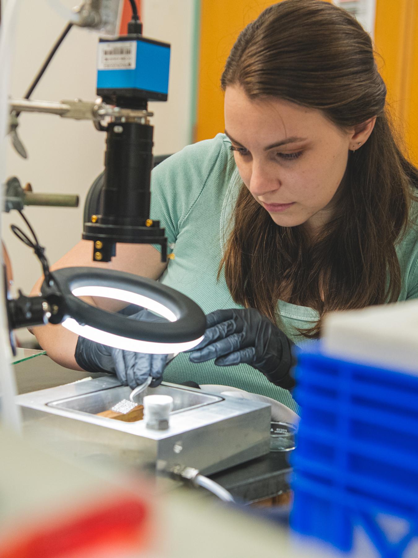 Researcher studies water droplets under a light