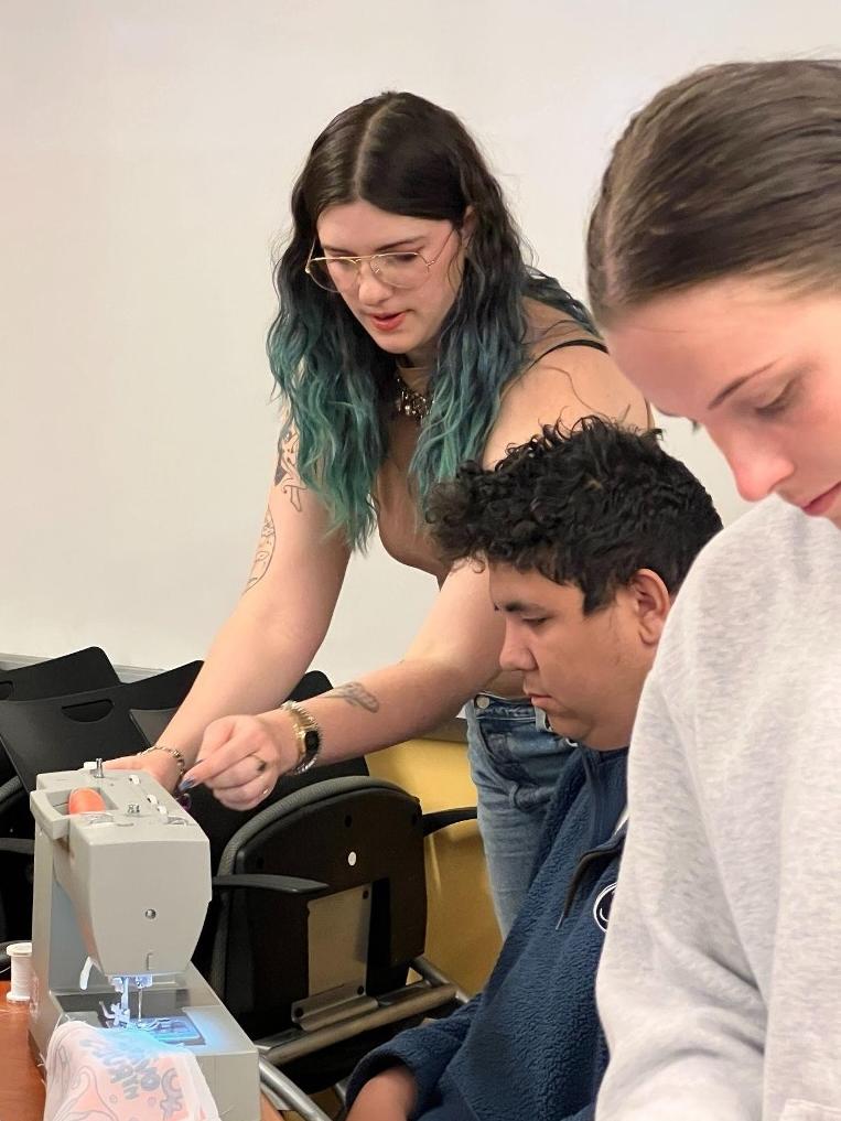 Maggie Rose Condit-Summerson instructs a student on sewing techniques.